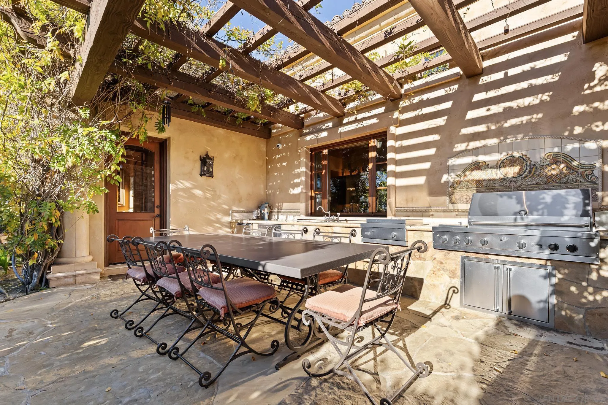 18486 Via Candela Rancho Santa Fe, CA 92091 - Photo 25 of 34 a view of a patio with table and chairs and couches with wooden fence and plants