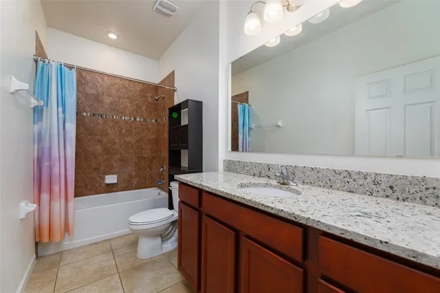 a bathroom with a granite countertop toilet sink and mirror