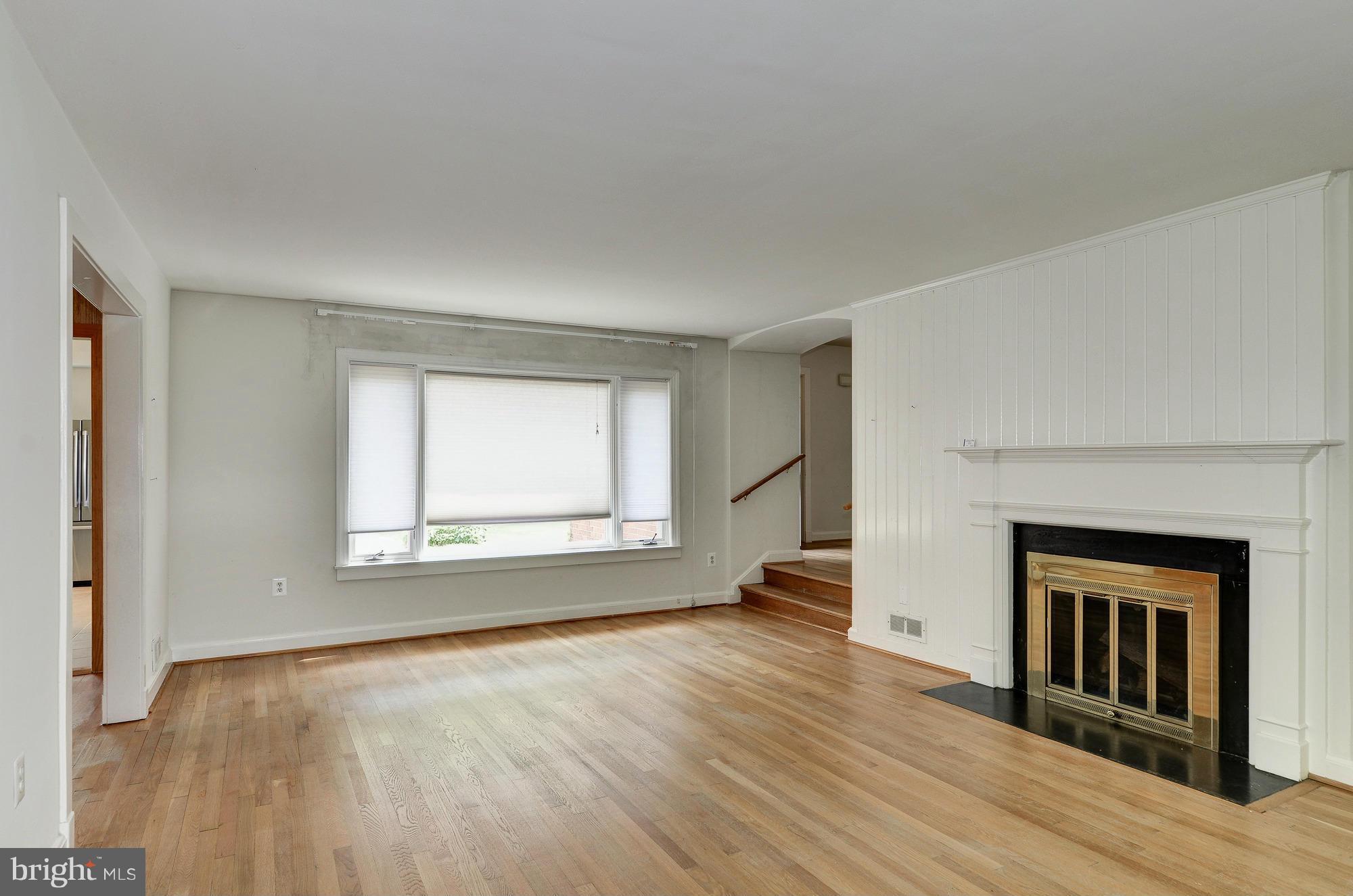 3238 Park View Road Chevy Chase, MD 20815 - Photo 3 of 28 an empty room with wooden floor fireplace and windows