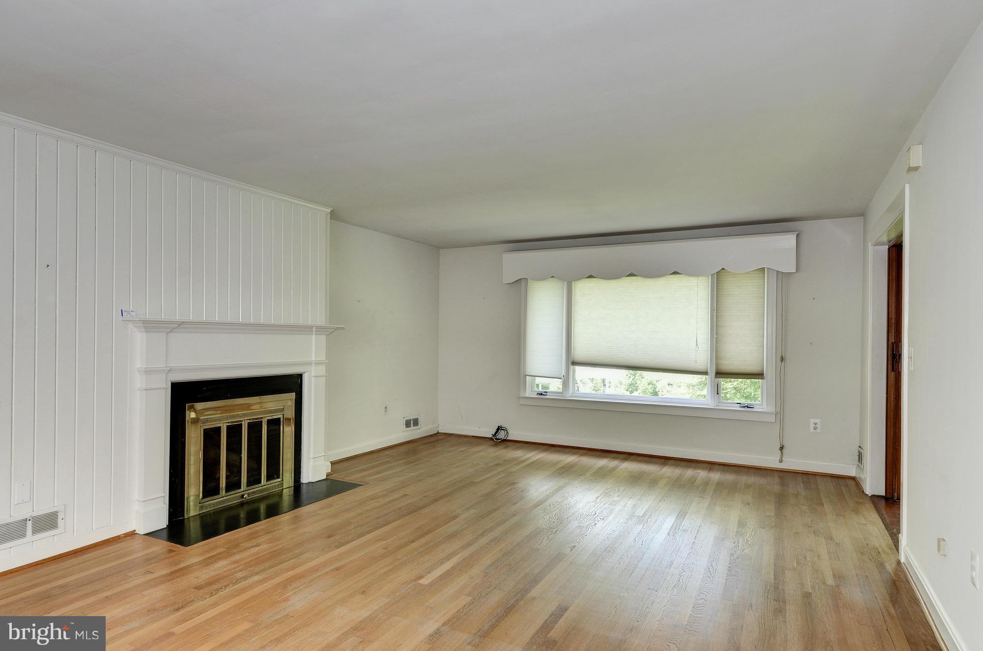 3238 Park View Road Chevy Chase, MD 20815 - Photo 4 of 28 a view of an empty room with wooden floor fireplace and a window