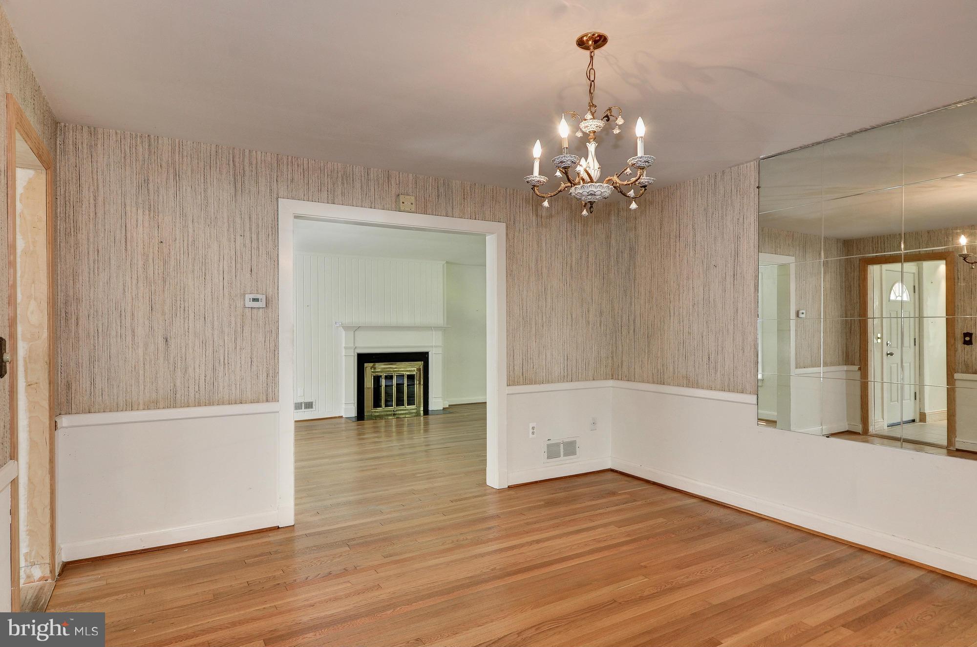 3238 Park View Road Chevy Chase, MD 20815 - Photo 6 of 28 a view of a livingroom with a fireplace wooden floor and a chandelier