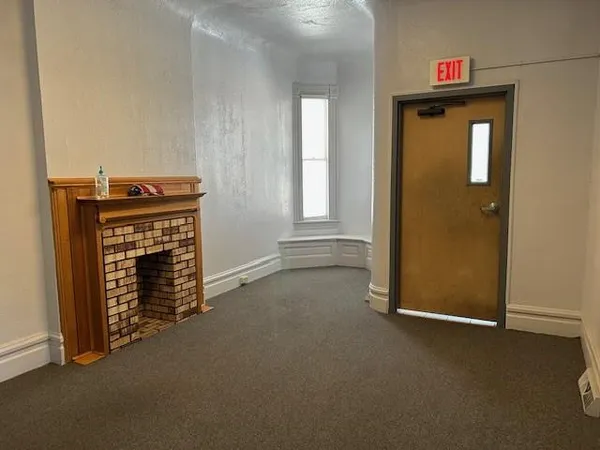 an empty room with windows and cabinet