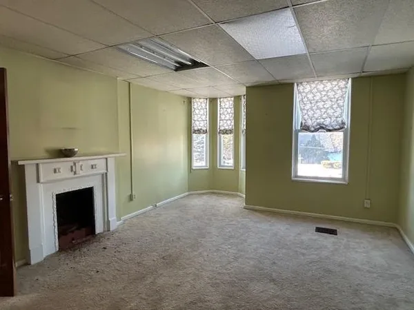 a view of an empty room with a fireplace and a window