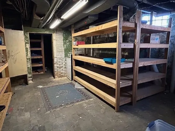 a view of an empty room with storage and a window