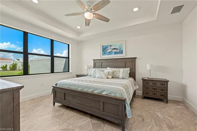 a bedroom with a large bed and a flat tv screen on dresser