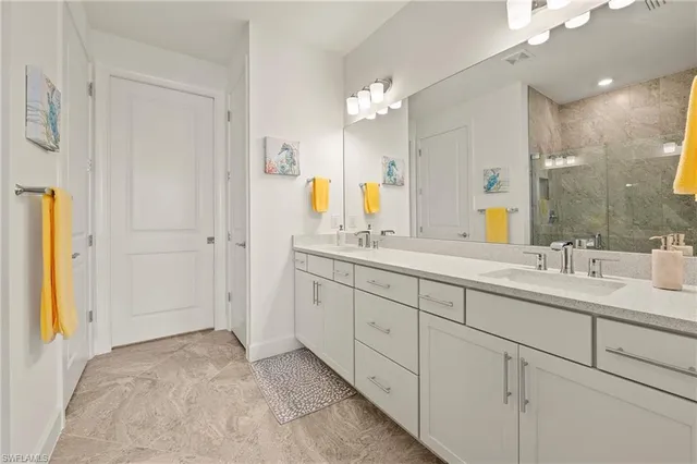 a bathroom with a granite countertop shower sink and mirror