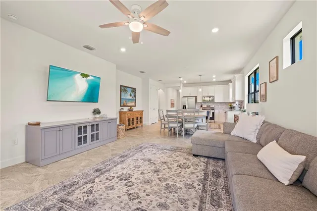 a kitchen with stainless steel appliances granite countertop a stove a sink a refrigerator a microwave oven and a refrigerator with white cabinets