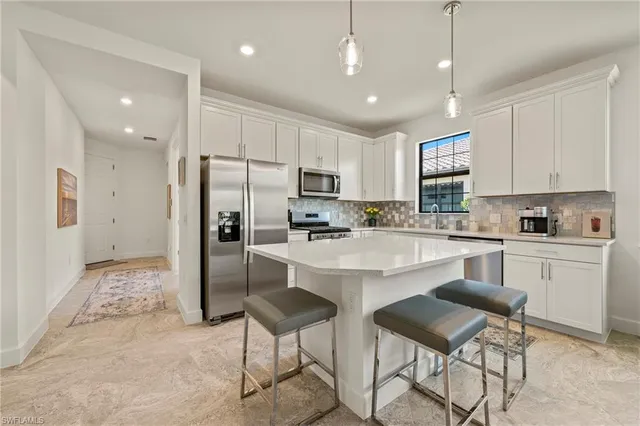 a kitchen with granite countertop a refrigerator and a stove top oven