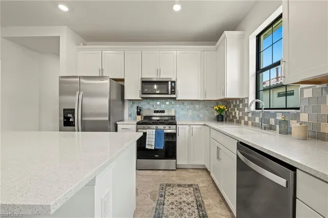 a large kitchen with kitchen island a dining table chairs and white cabinets