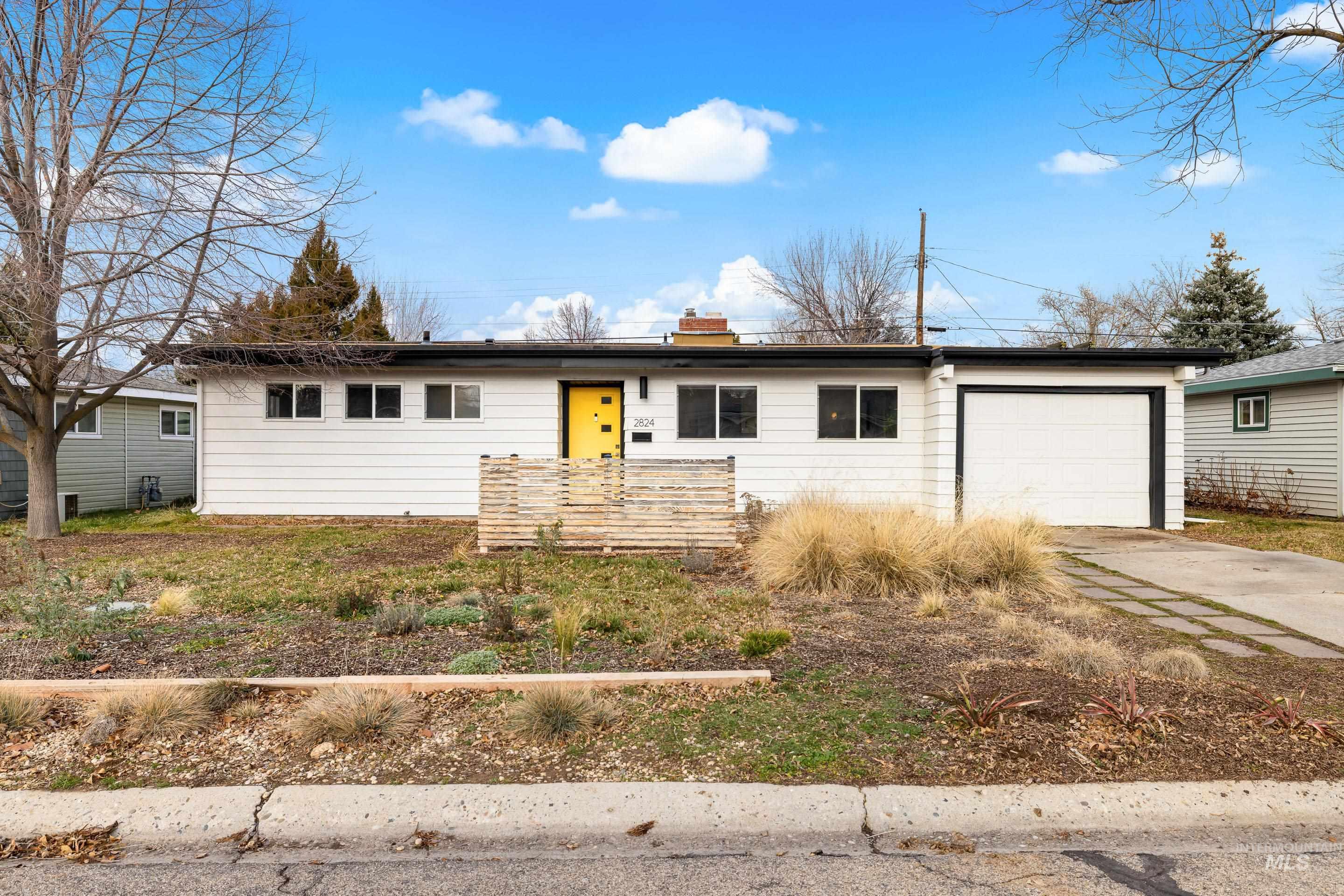 Single story home featuring a chimney, concrete driveway, and a garage