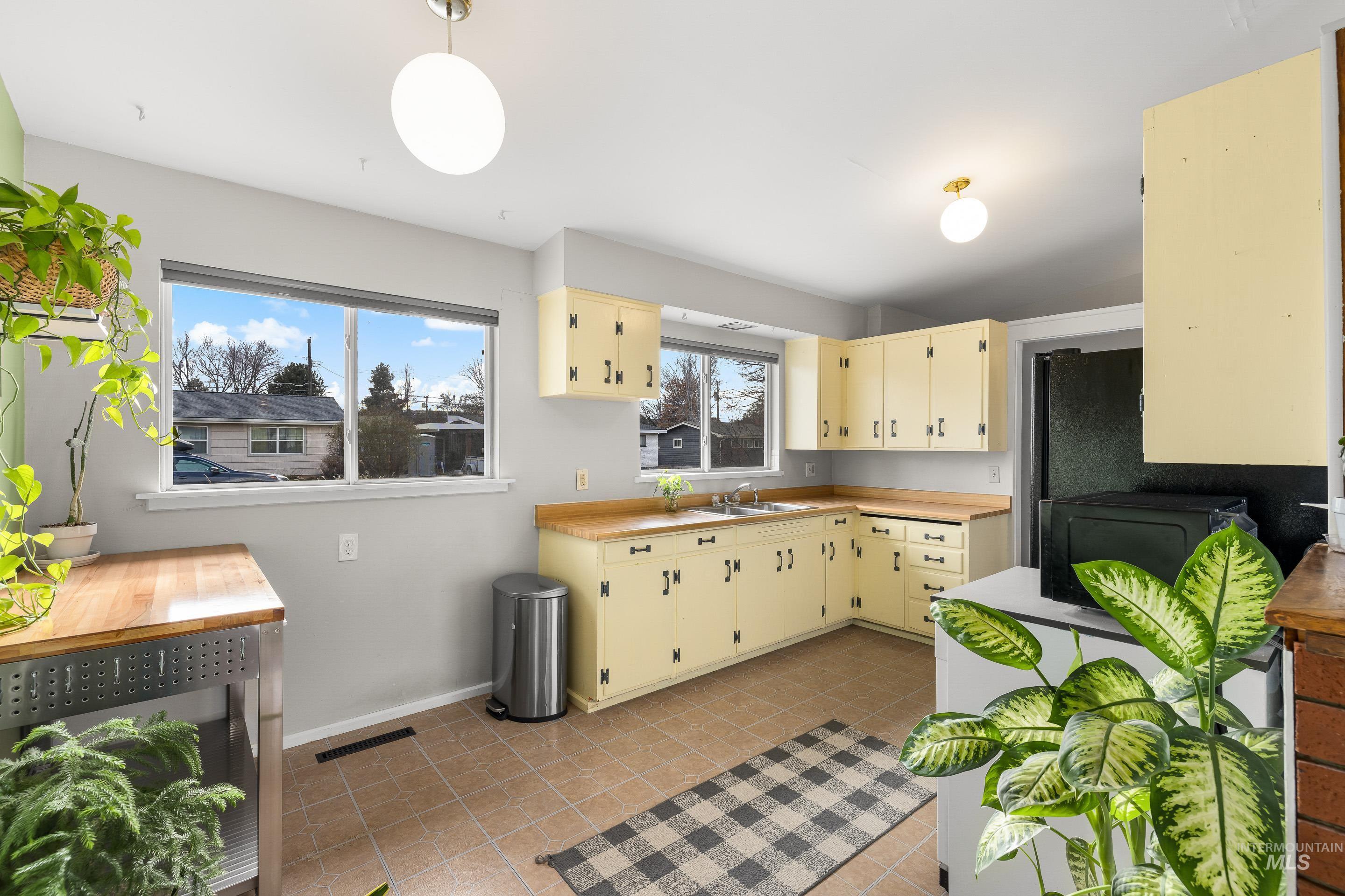 2824 West Kathryn Street Boise, ID 83705 - Photo 18 of 40 Kitchen with cream cabinetry, light countertops, light tile patterned flooring, and pendant lighting