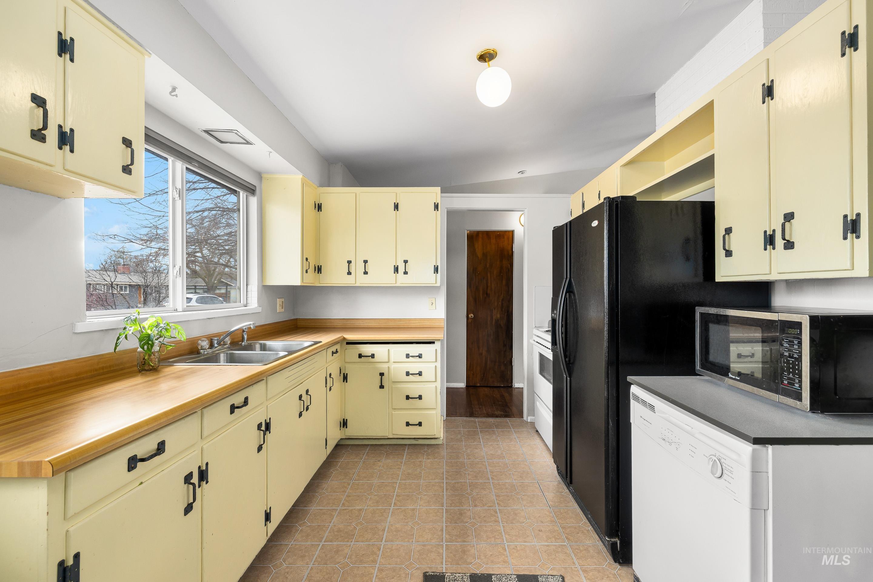 2824 West Kathryn Street Boise, ID 83705 - Photo 21 of 40 Kitchen with white appliances, cream cabinets, light countertops, open shelves, and light tile patterned floors