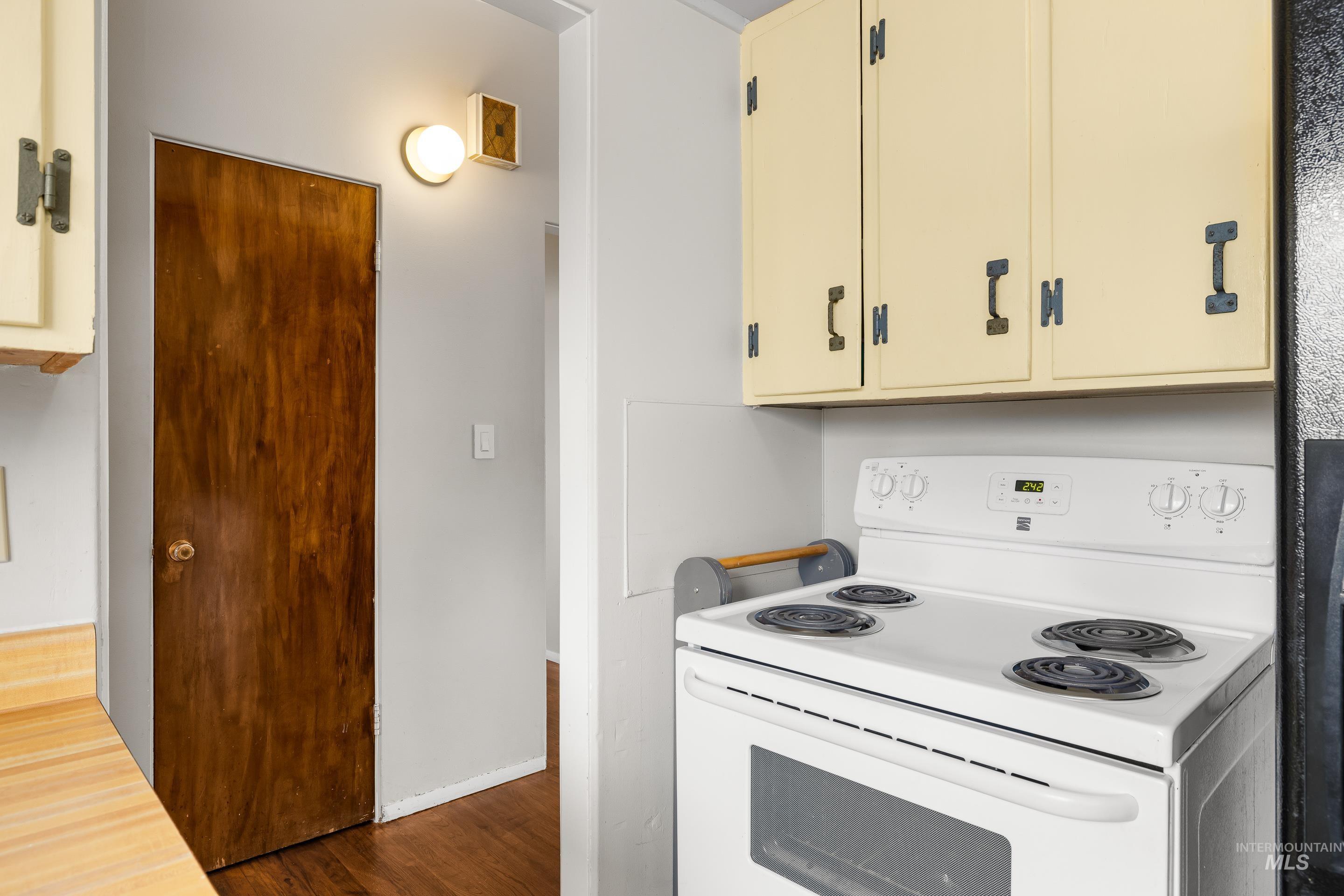 2824 West Kathryn Street Boise, ID 83705 - Photo 24 of 40 Kitchen featuring electric stove, dark wood-type flooring, light countertops, and cream cabinets