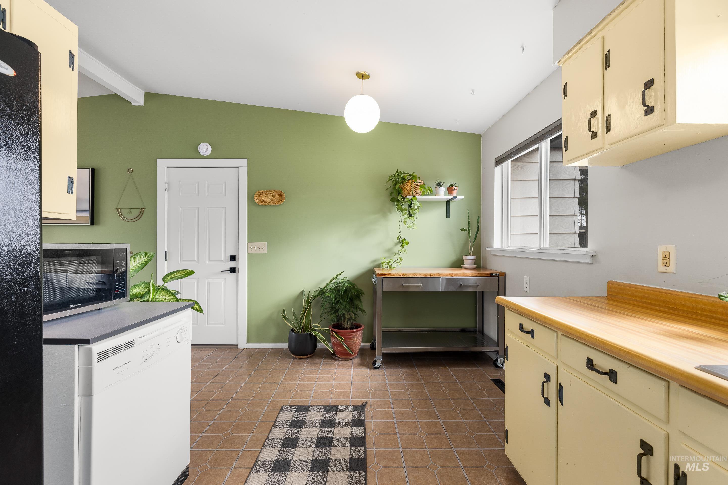 2824 West Kathryn Street Boise, ID 83705 - Photo 25 of 40 Kitchen featuring stainless steel microwave, dishwasher, light countertops, cream cabinets, and freestanding refrigerator