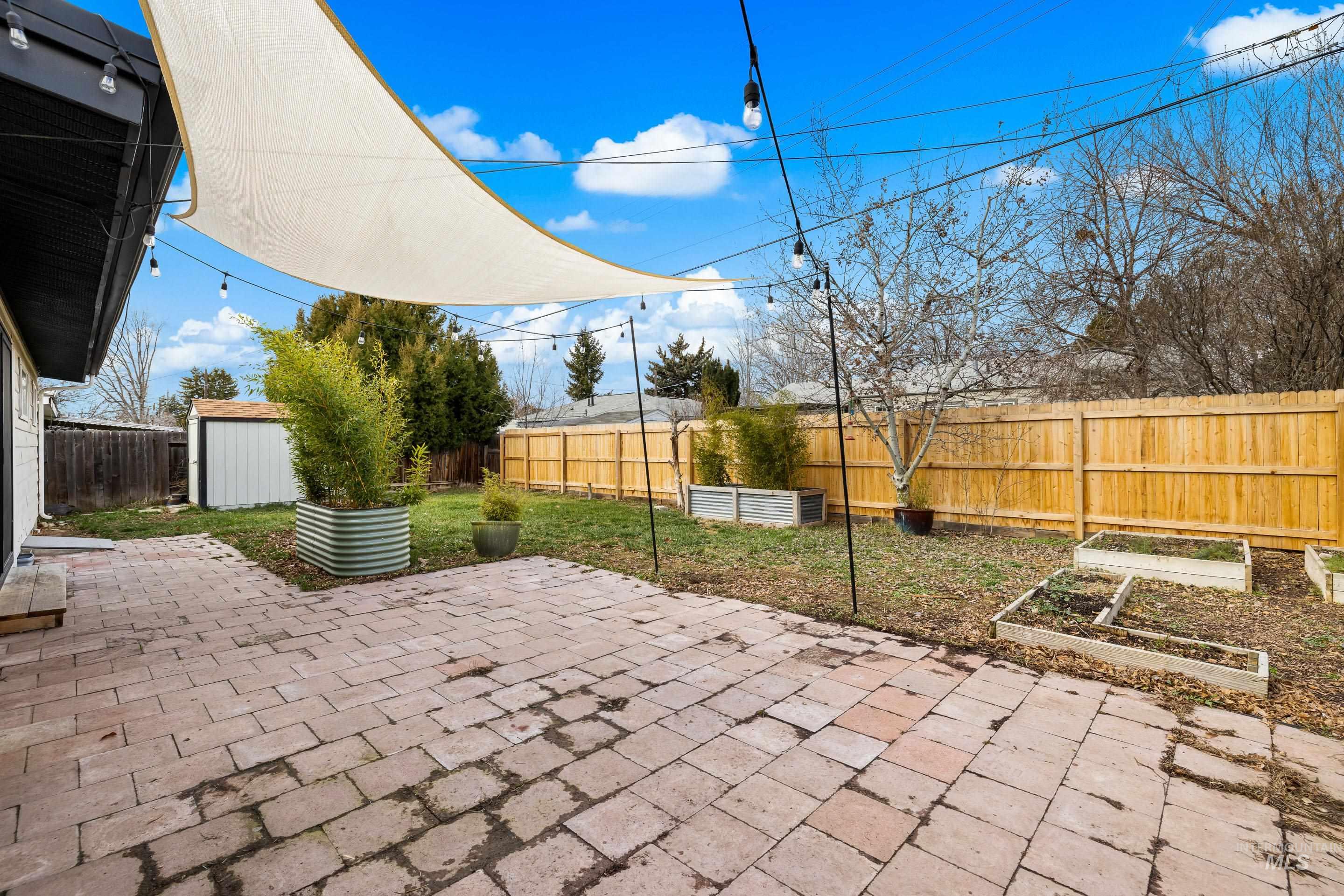 2824 West Kathryn Street Boise, ID 83705 - Photo 35 of 40 Fenced backyard with a patio area, a vegetable garden, and a storage unit