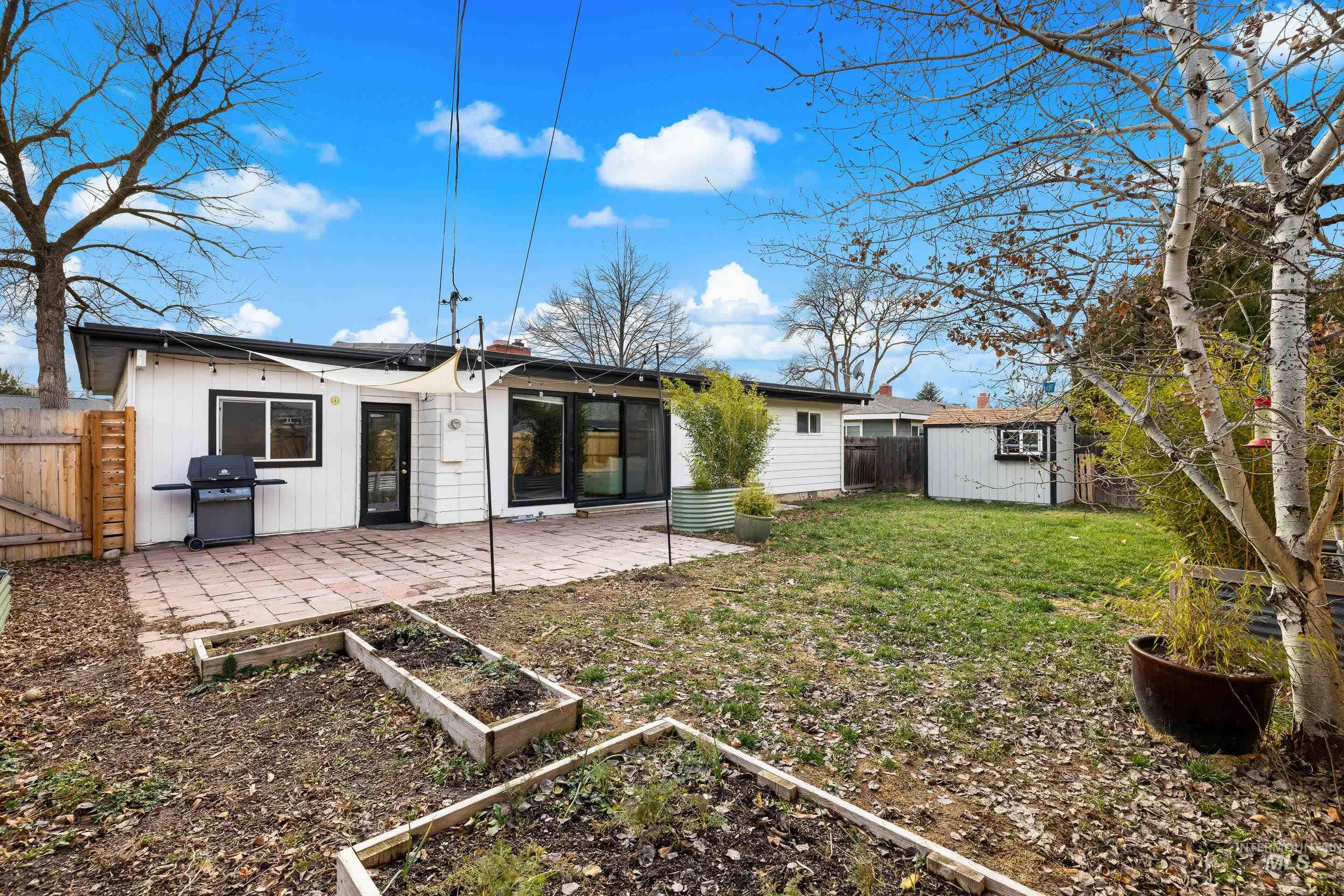 2824 West Kathryn Street Boise, ID 83705 - Photo 37 of 40 Back of property with a fenced backyard, a patio area, a shed, and a garden