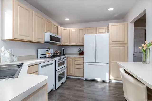 a kitchen with a refrigerator stove and wooden cabinets