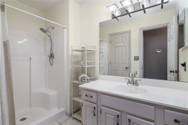 a bathroom with a shower sink vanity and mirror