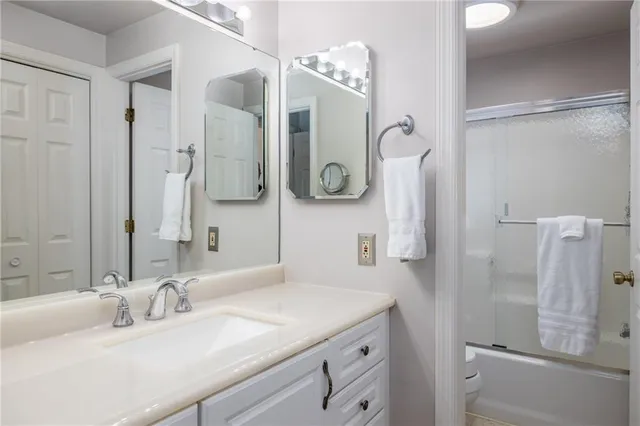 a bathroom with a sink vanity granite tub and shower