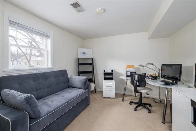 a livingroom with workspace and a couch