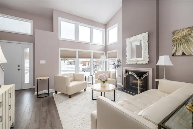 a living room with furniture a fireplace and a large window