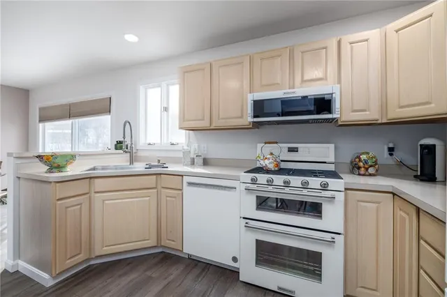 a kitchen with stainless steel appliances granite countertop a stove a sink and a microwave