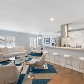 a living room with furniture a large window and wooden floor