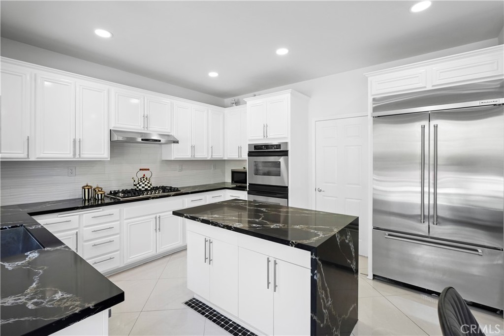 20621 Pesaro Way Porter Ranch, CA 91326 - Photo 12 of 45 a kitchen with a center island refrigerator and cabinets