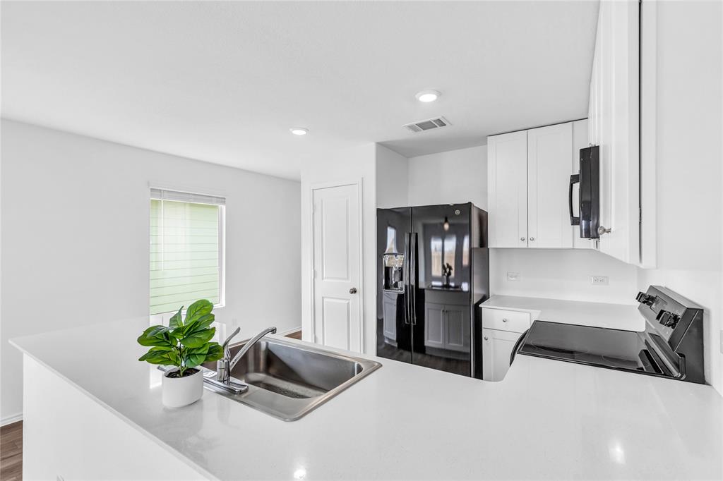 516 Rancho Del Cielo Loop Jarrell, TX 76537 - Photo 14 of 33 a kitchen with a refrigerator and a sink