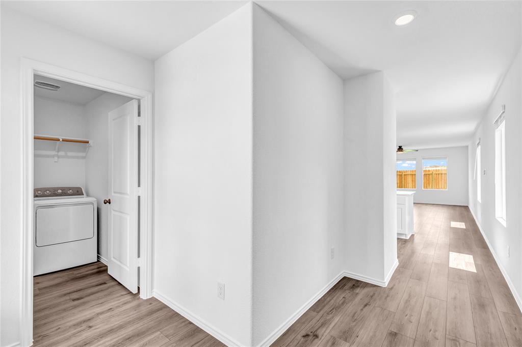 516 Rancho Del Cielo Loop Jarrell, TX 76537 - Photo 16 of 33 a view of a hallway with wooden floor and a sink