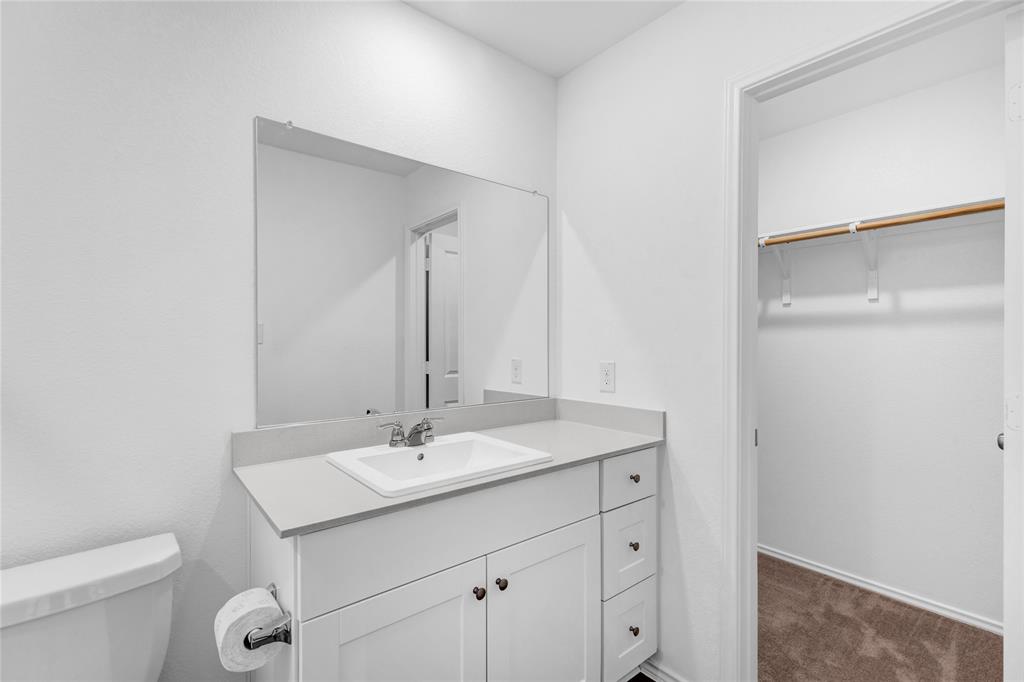 516 Rancho Del Cielo Loop Jarrell, TX 76537 - Photo 22 of 33 a bathroom with a toilet a sink and a mirror