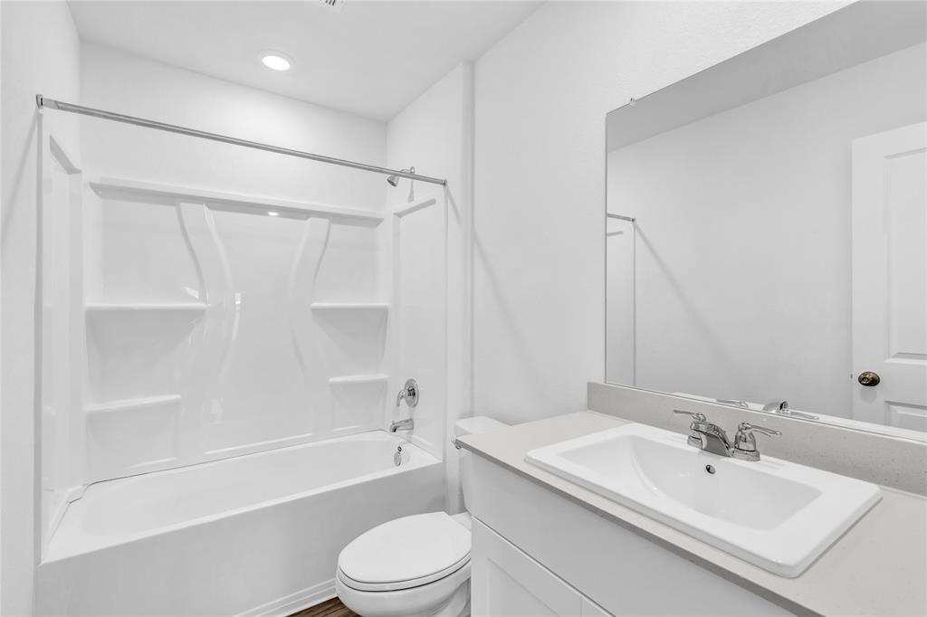516 Rancho Del Cielo Loop Jarrell, TX 76537 - Photo 28 of 33 a bathroom with a bathtub shower sink vanity and toilet