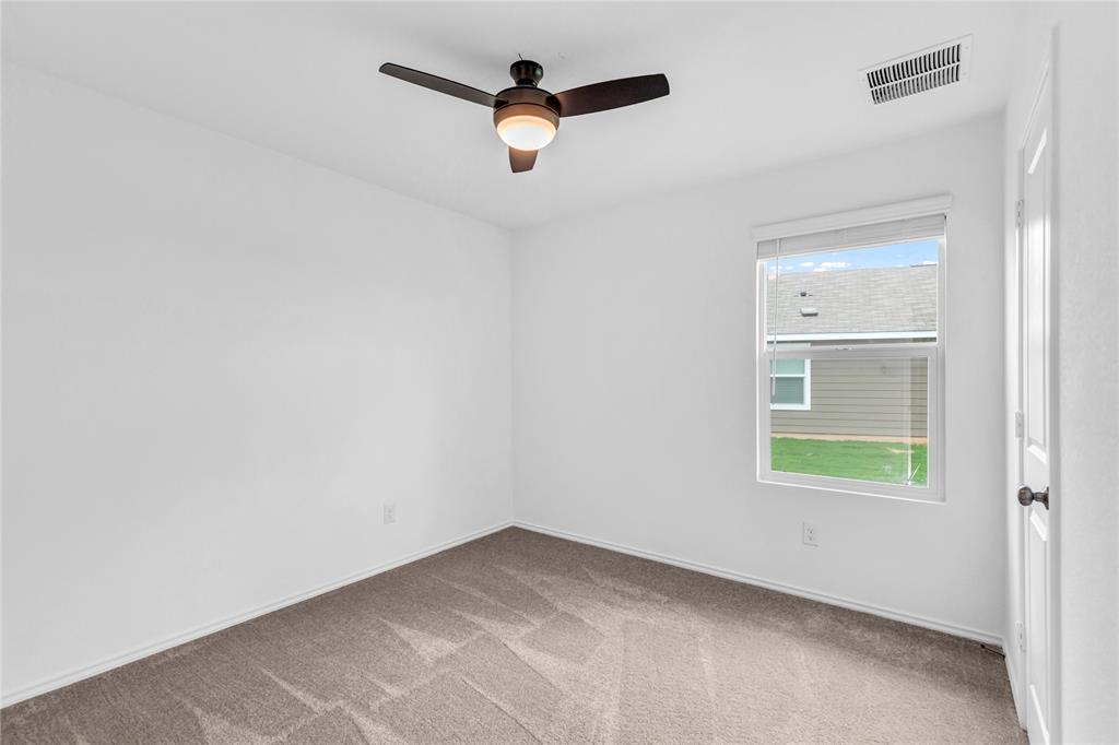 516 Rancho Del Cielo Loop Jarrell, TX 76537 - Photo 29 of 33 an empty room with a window and a ceiling fan