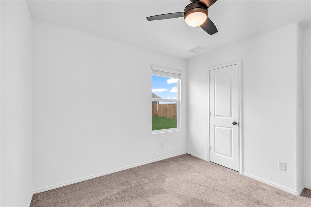516 Rancho Del Cielo Loop Jarrell, TX 76537 - Photo 30 of 33 an empty room with windows and fan