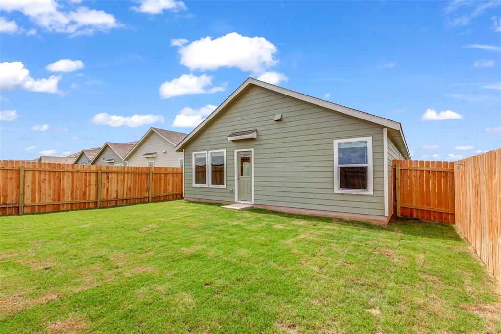 516 Rancho Del Cielo Loop Jarrell, TX 76537 - Photo 31 of 33 a view of a backyard with a garden and deck