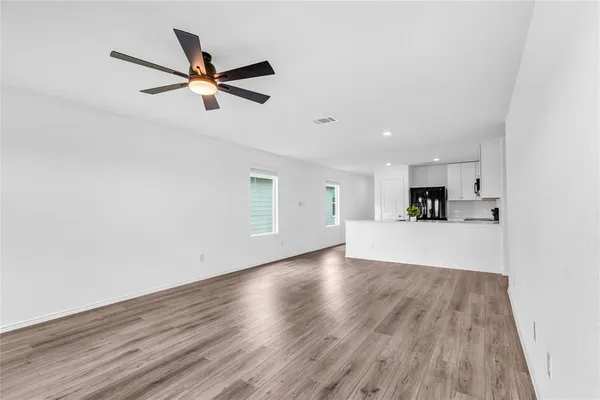 a view of a livingroom with wooden floor and a ceiling fan