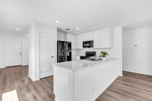 a kitchen with stainless steel appliances a refrigerator sink and white cabinets