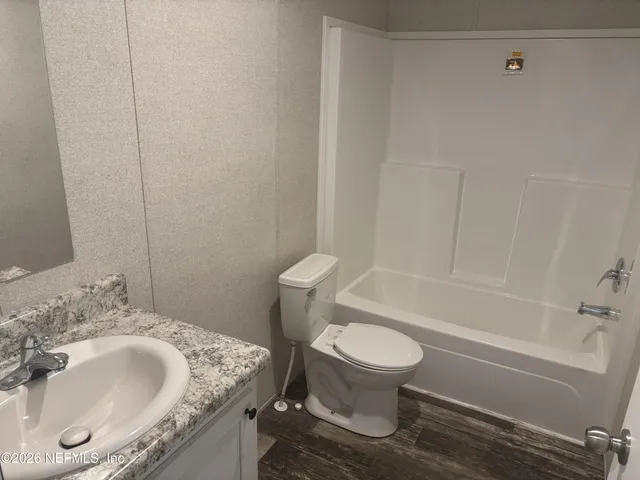a bathroom with a granite countertop sink toilet and a bathtub