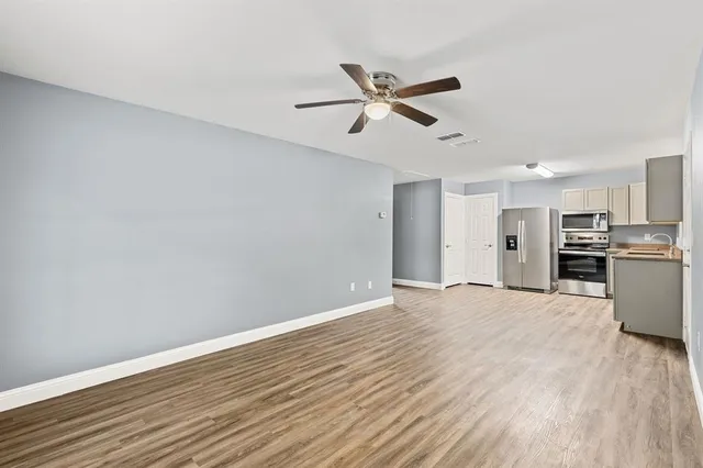 a view of empty room with wooden floor and window