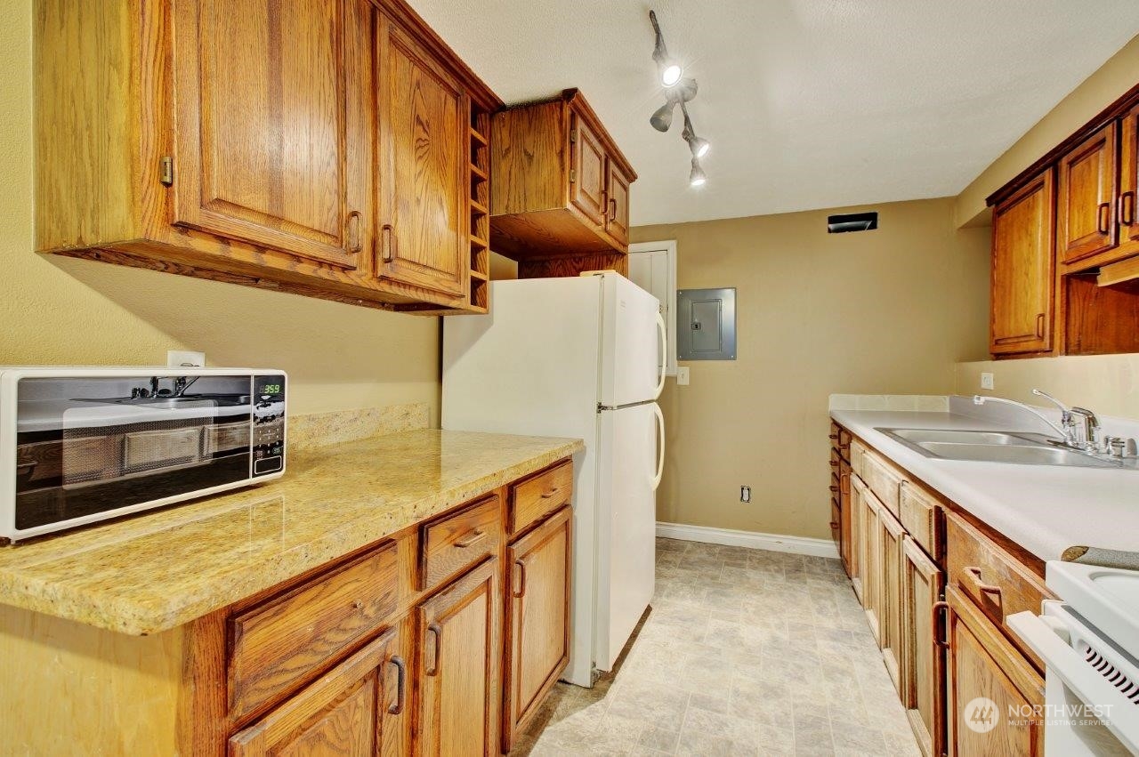 3906 South Pilgrim Street Seattle, WA 98118 - Photo 14 of 29 a kitchen with stainless steel appliances granite countertop a sink a stove and a refrigerator