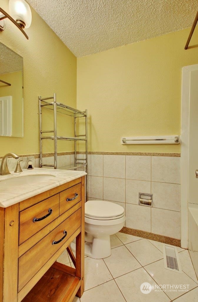 3906 South Pilgrim Street Seattle, WA 98118 - Photo 20 of 29 a bathroom with a granite countertop toilet sink and mirror
