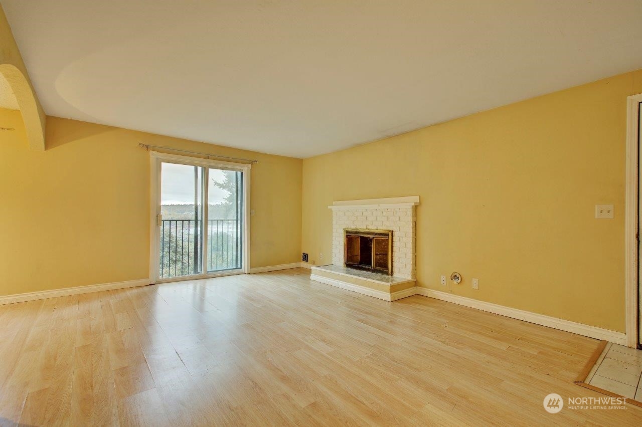 3906 South Pilgrim Street Seattle, WA 98118 - Photo 4 of 29 a view of an empty room with a fireplace and a window