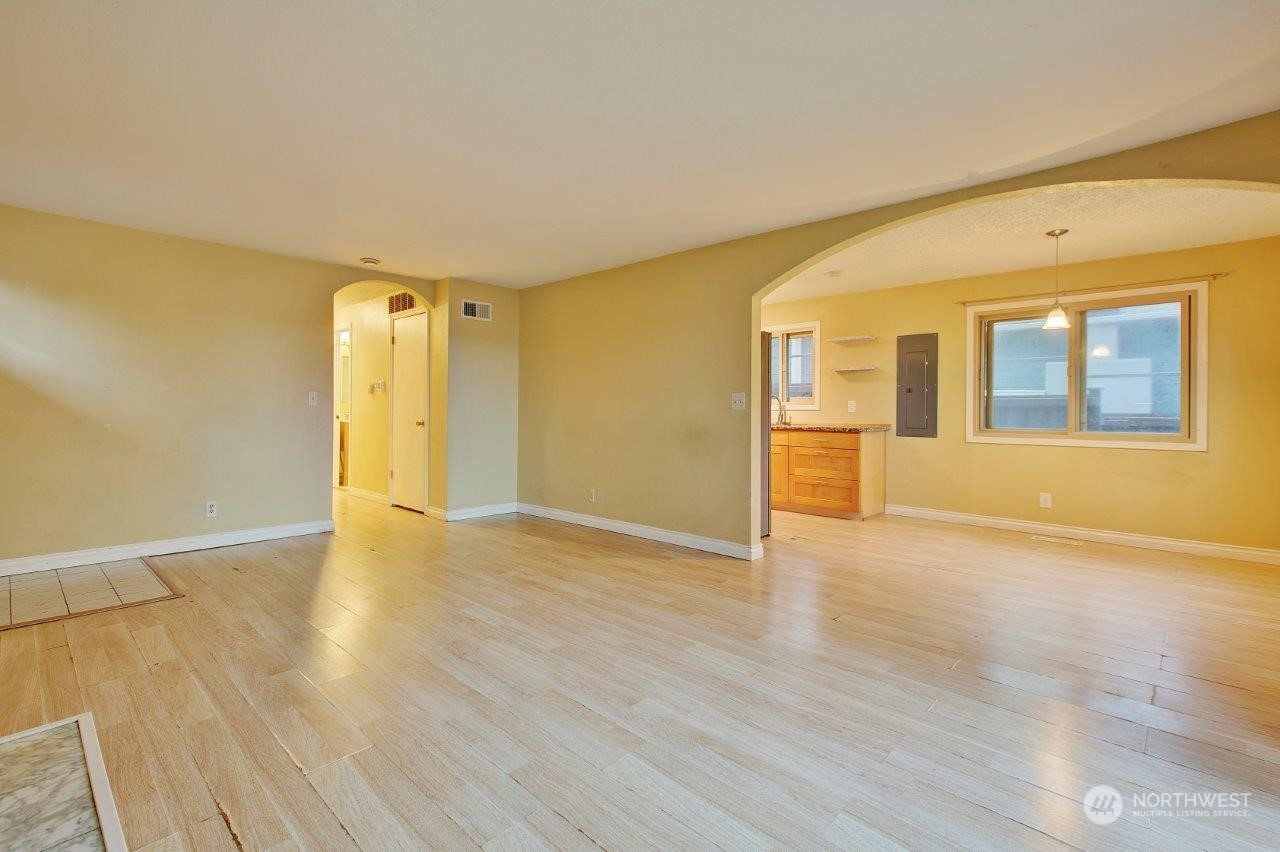 3906 South Pilgrim Street Seattle, WA 98118 - Photo 5 of 29 a view of an empty room with wooden floor and a window