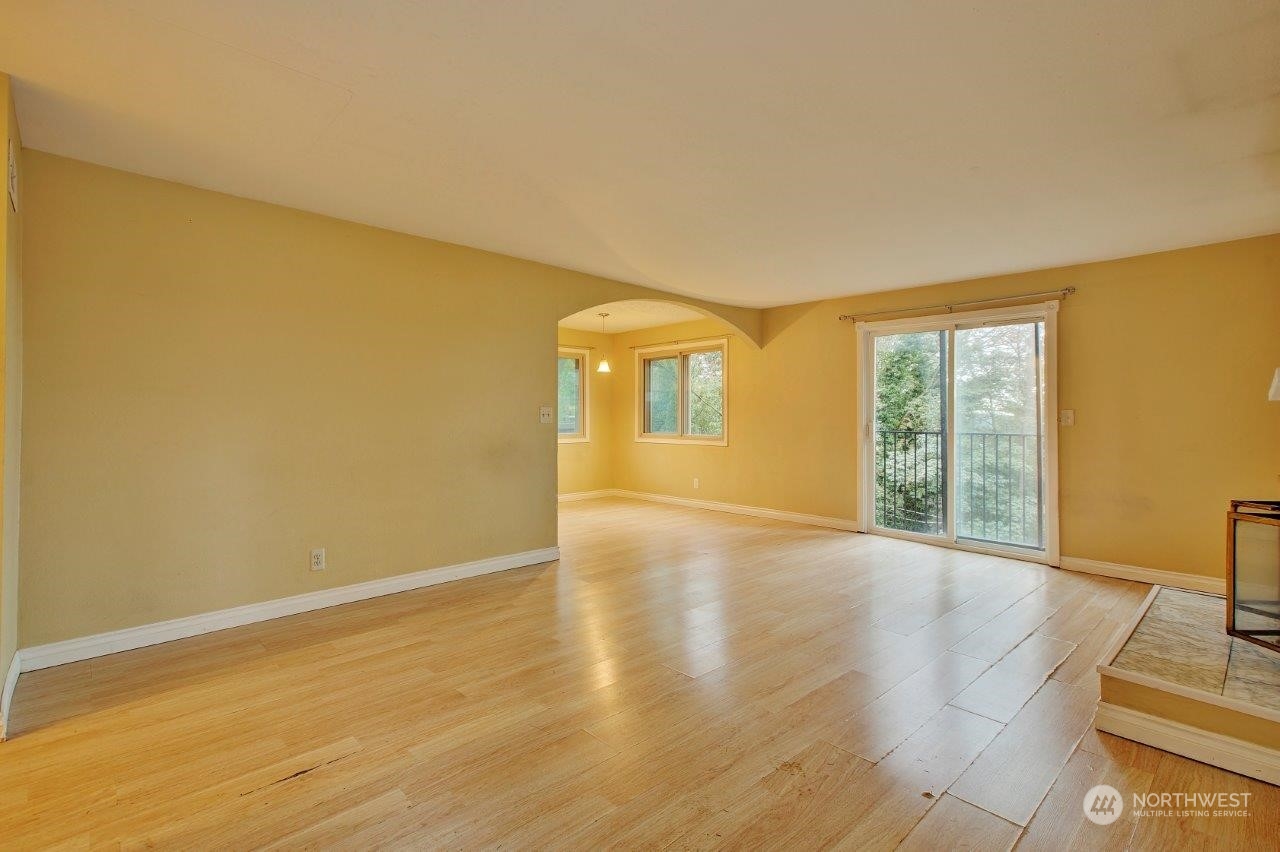 3906 South Pilgrim Street Seattle, WA 98118 - Photo 6 of 29 a view of an empty room with wooden floor and a window