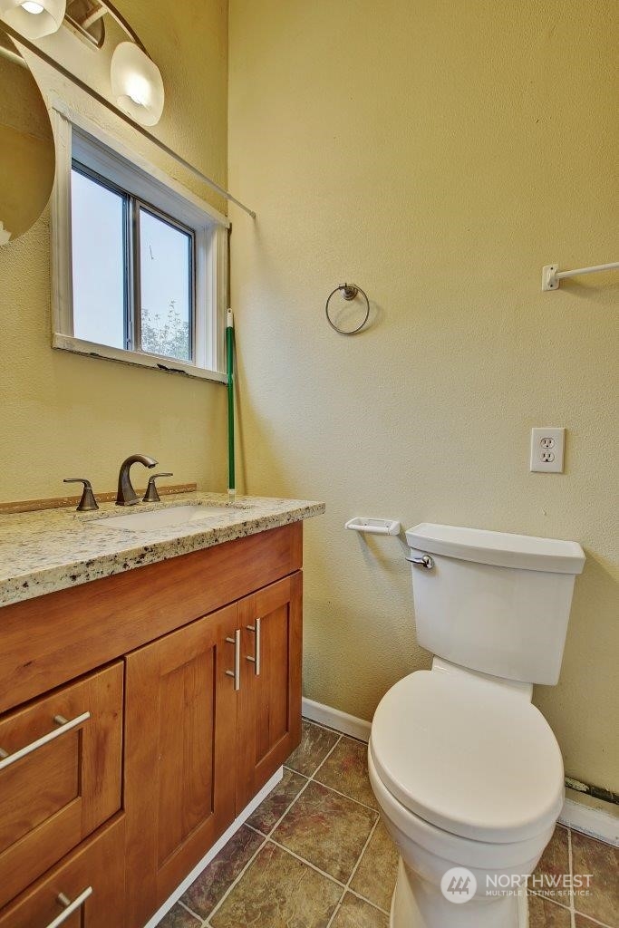 3906 South Pilgrim Street Seattle, WA 98118 - Photo 9 of 29 a bathroom with a granite countertop toilet sink and mirror