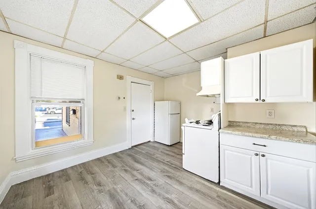 a kitchen with a stove a refrigerator and white cabinets