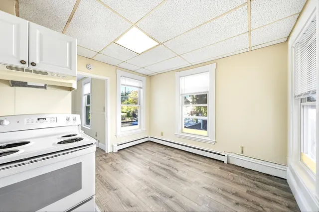 a view of a kitchen with wooden floor and electronic appliances