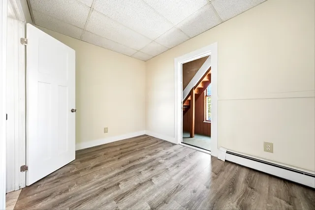 an empty room with wooden floor and natural light