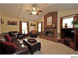 601 Trail Ridge Road Matthews, NC 28105 - Photo 4 of 16 a living room with furniture a flat screen tv and a fireplace