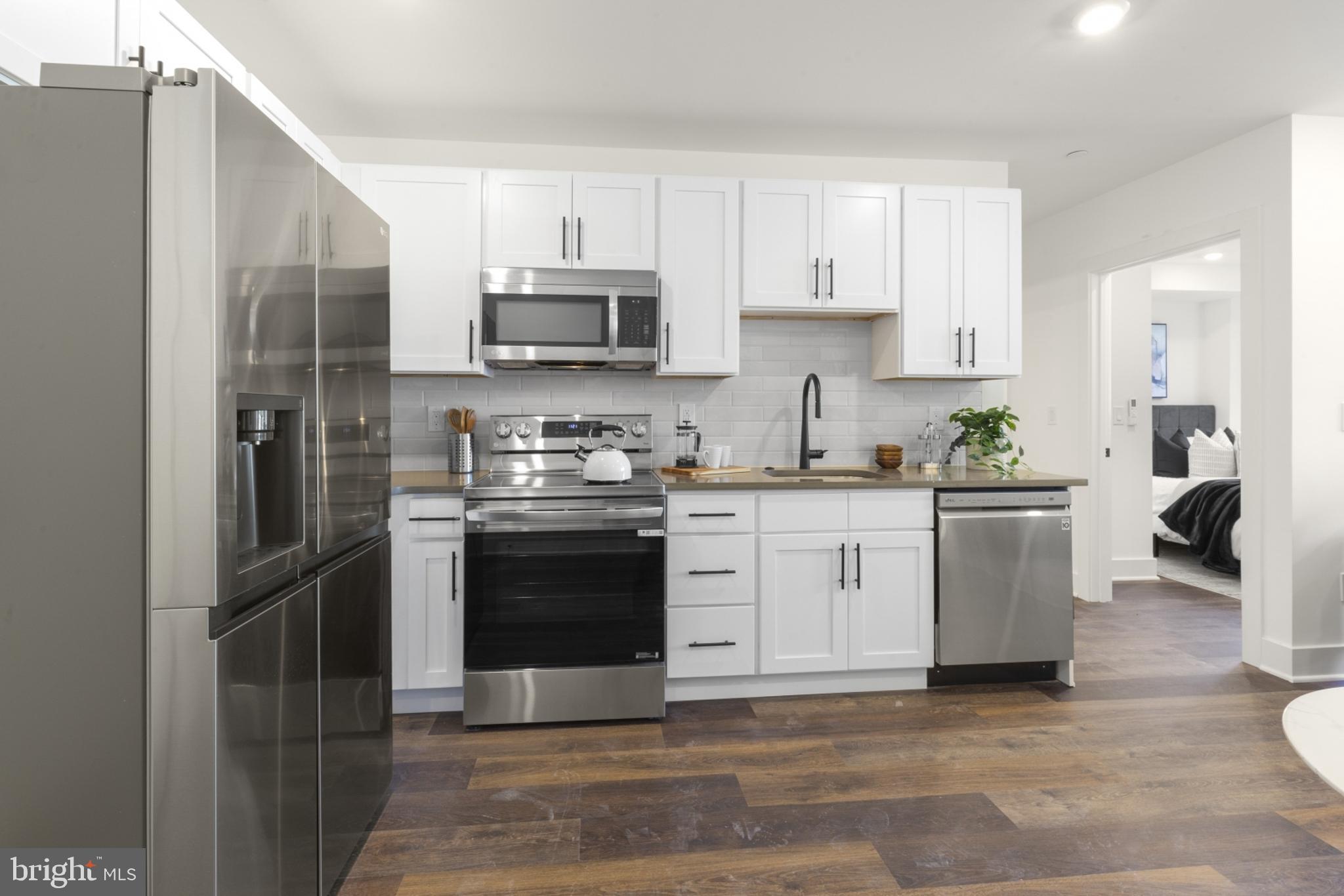 7037 Ridge Avenue, Unit 103 Philadelphia, PA 19128 - Photo 3 of 19 a kitchen with stainless steel appliances a stove a sink and a refrigerator